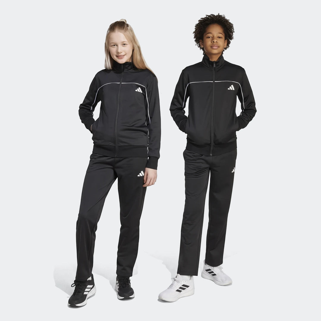 Two children, a boy and a girl, model black Kids Tricot Colour Pop Track Suits with white piping. They wear matching