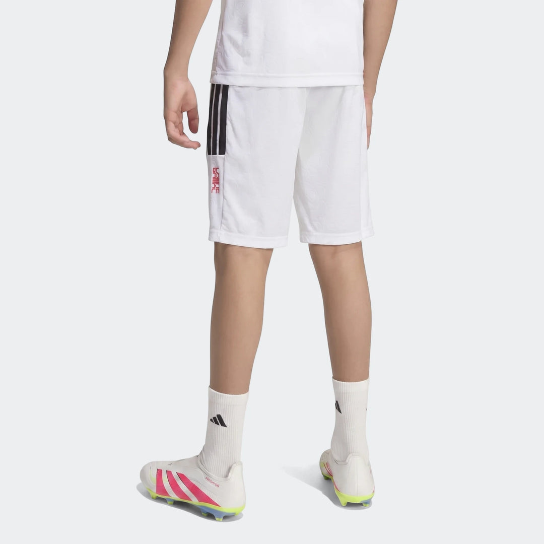 Youth wearing Lamine Yamal Hot Shorts in white with black stripes, white Adidas socks, and white, pink, yellow soccer cleats