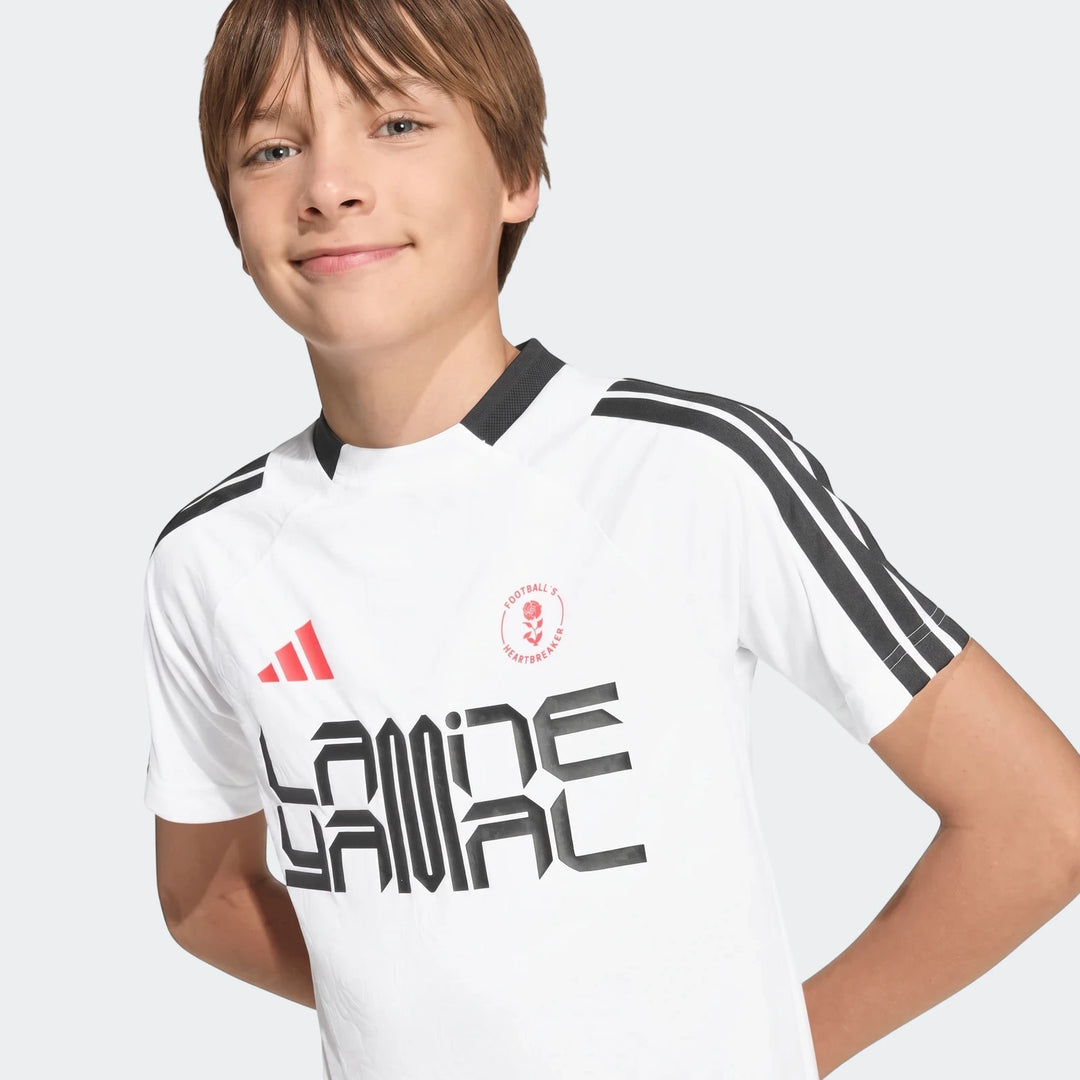 Lamine Yamal Training T-Shirt Kids in white with black stripes and red Adidas logo, worn by a smiling boy.