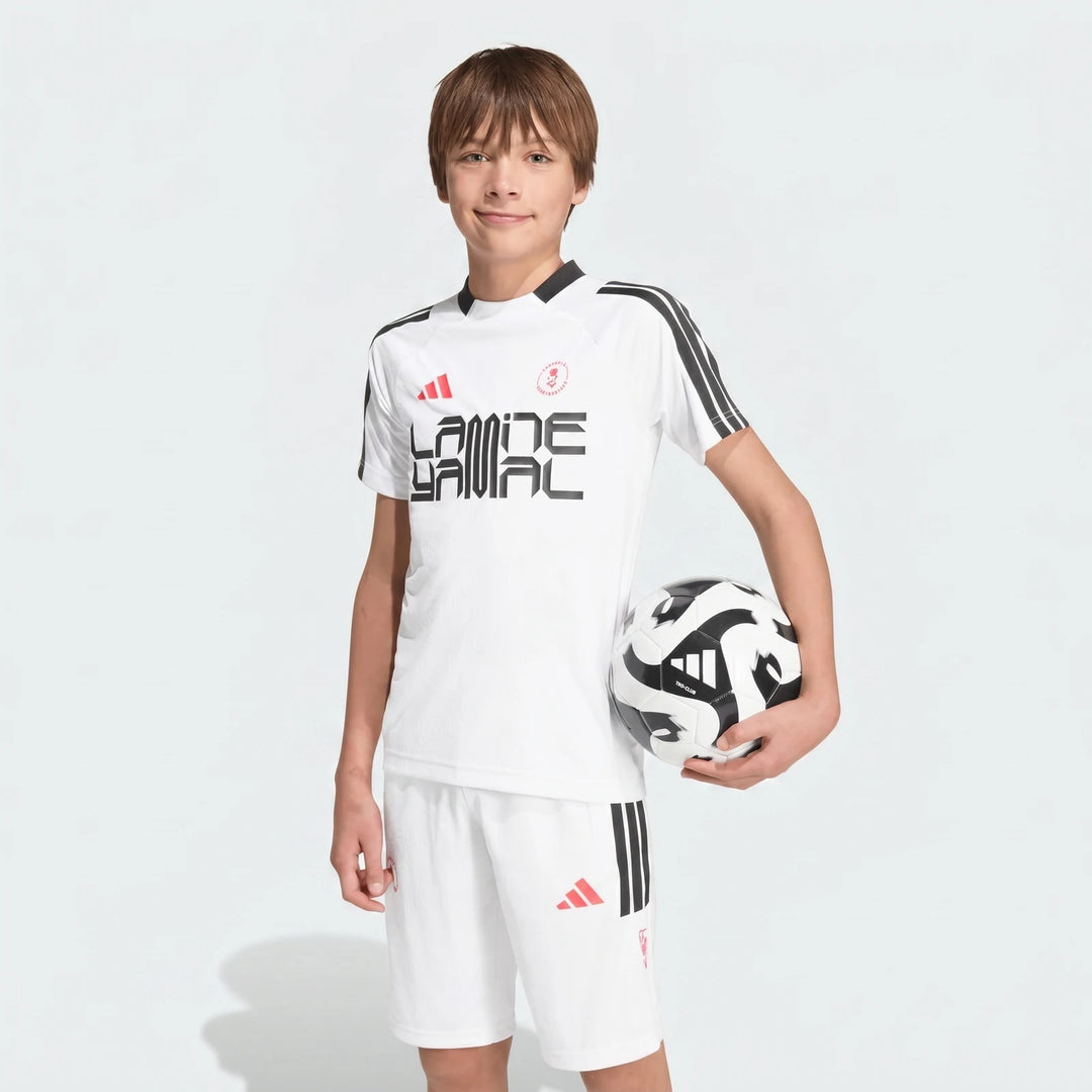 White short-sleeved Lamine Yamal Training T-Shirt for kids, worn by a boy holding a black and white soccer ball.