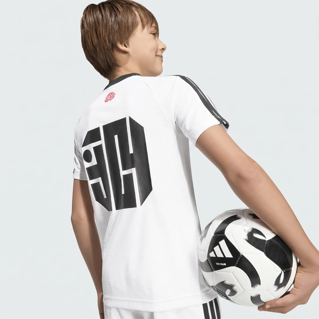 Lamine Yamal Training T-Shirt Kids in white, worn by a boy from behind holding a soccer ball.