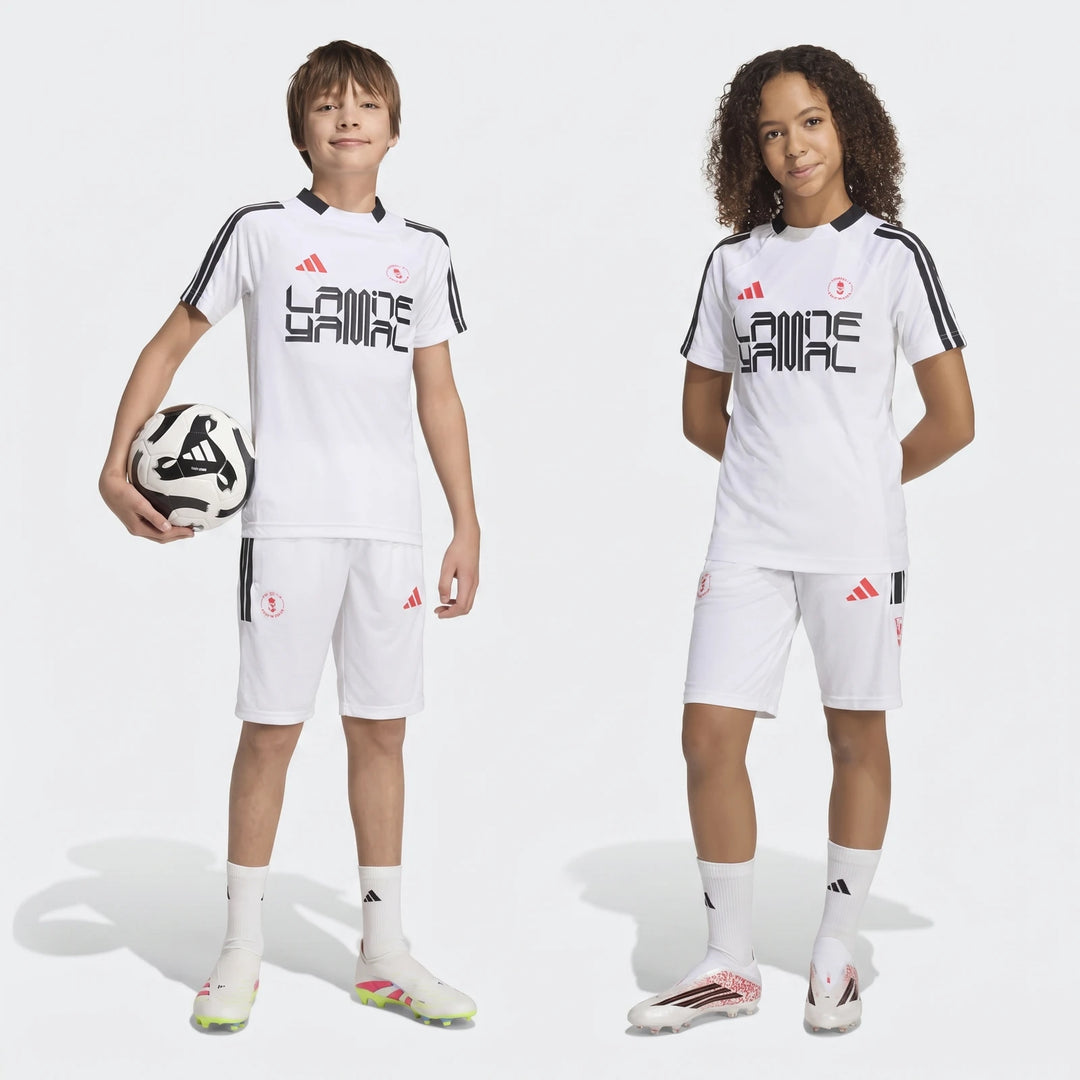 Two young models, a boy and a girl, stand full body in white Lamine Yamal Youth Hot Shorts soccer kits.