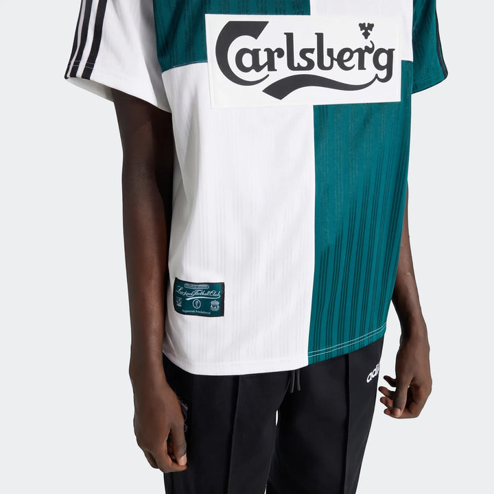 Model wears a white and dark green striped Liverpool Fc 1995 Away Jersey with Carlsberg logo and official tag.