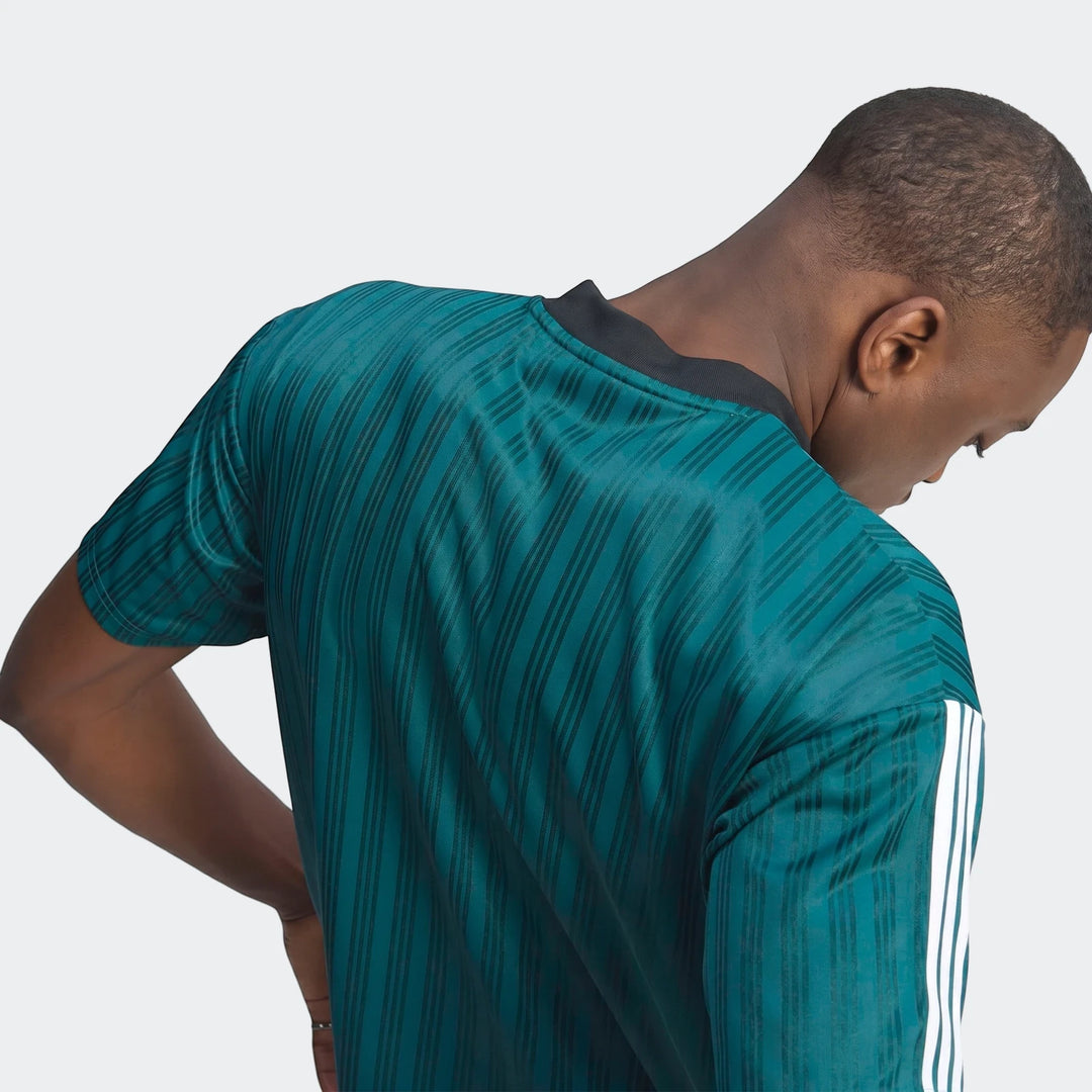 Back view of a person wearing a dark teal Liverpool FC 1995 Poly T-Shirt with vertical stripes and white sleeve accents.