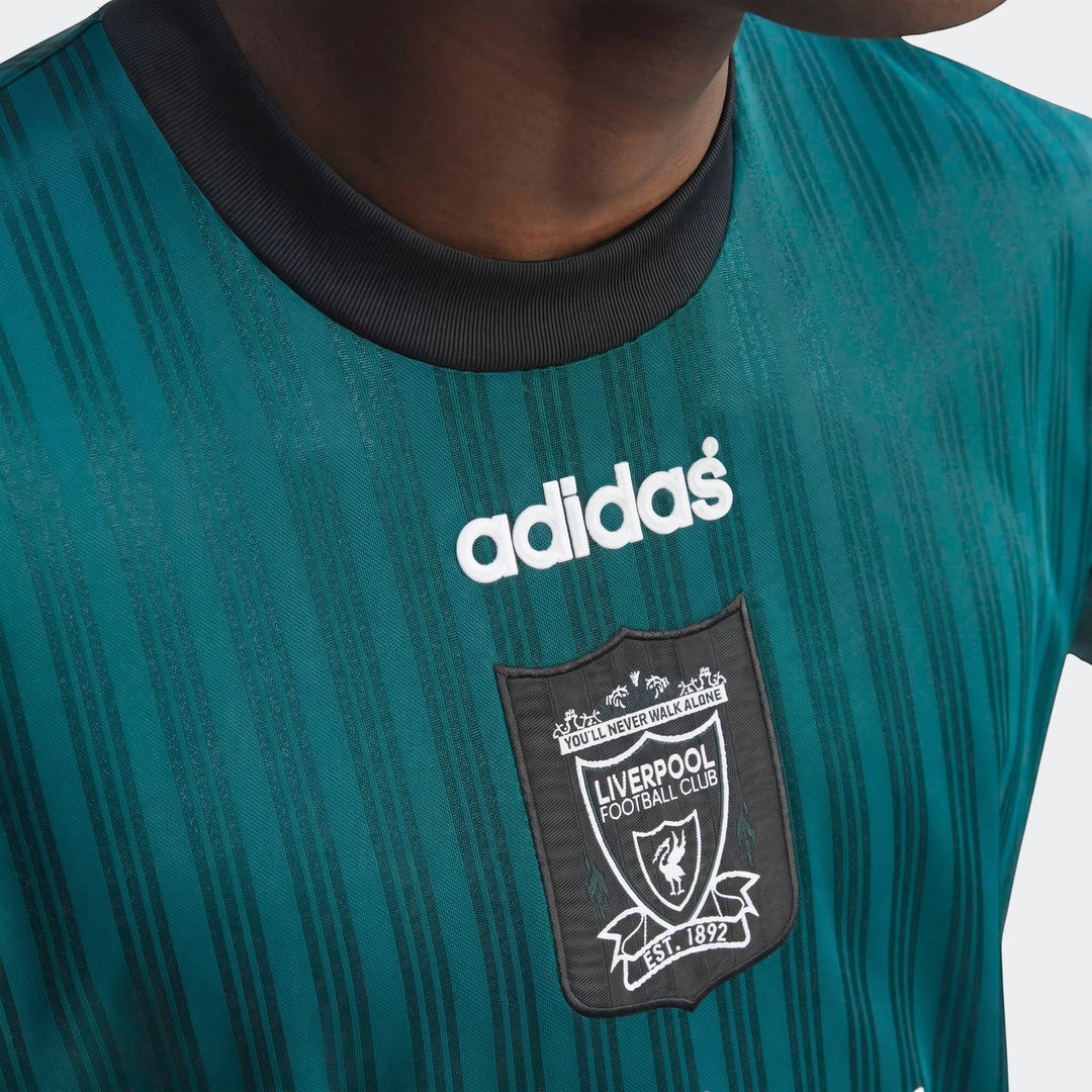 Close-up of a teal green Liverpool Fc 1995 Poly T-Shirt with black collar, featuring the white Adidas logo and the Liverpool