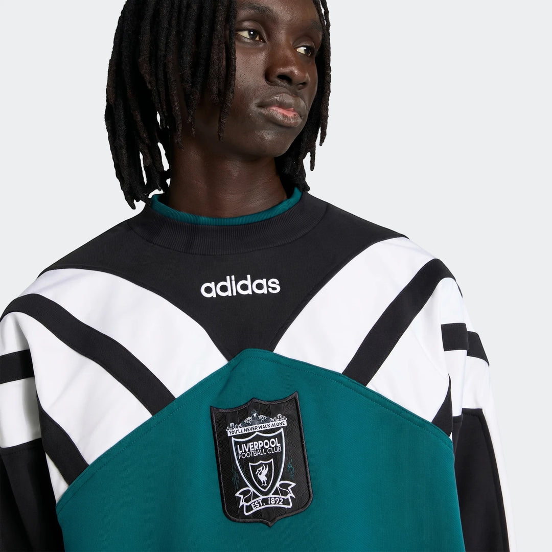 Male model wearing a vintage Liverpool FC 1995 sweatshirt in black, white, and teal, featuring the embroidered club crest.