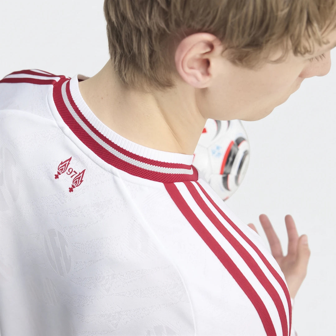 Person in white Liverpool FC 26/27 Away Authentic Longsleeve Jersey, showing red shoulder stripes and '97' flame graphic on