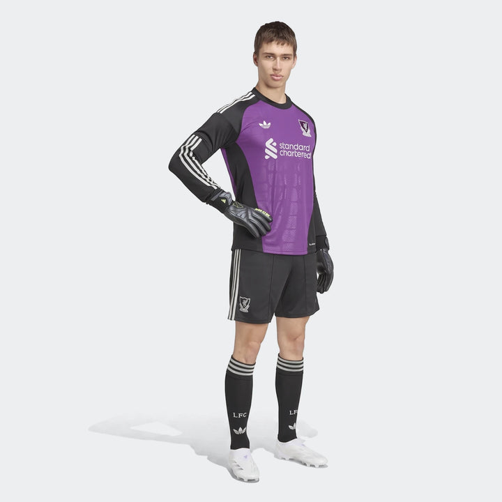 Young male model wearing the Liverpool FC 26/27 Away Goalkeeper Jersey in purple and black with matching shorts, socks, and