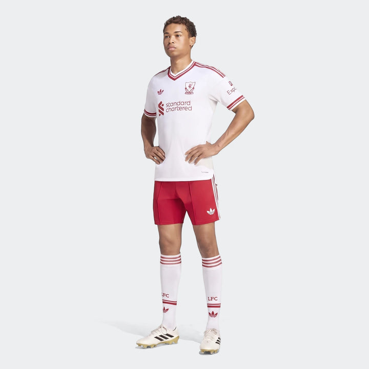 Male model wearing a white Liverpool Fc 26/27 Away Jersey Authentic, red shorts, and white socks, full body view.