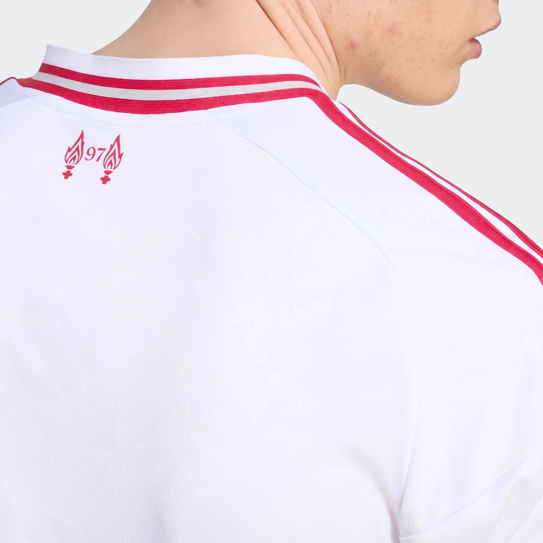 Close-up of the back of a white Liverpool FC 26/27 away jersey with red shoulder stripes and a red '97' flame logo worn by a