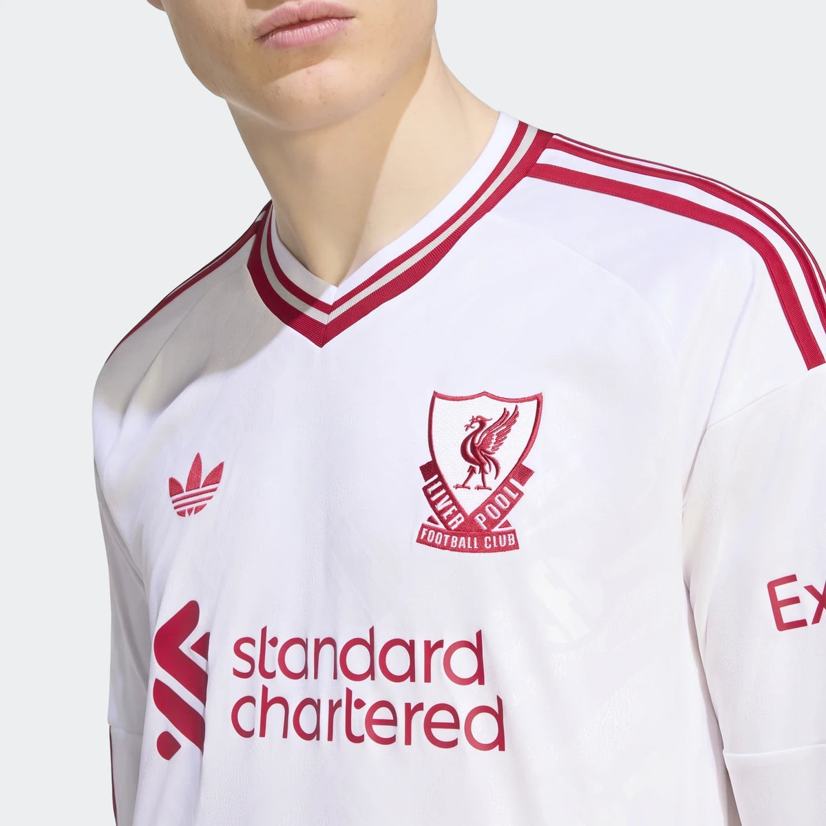 Close-up of a white and red Liverpool FC 26/27 Away Longsleeve Jersey for men, featuring team crest and sponsor logo.