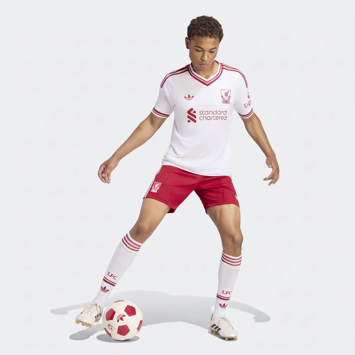 Male model wearing Liverpool FC 26/27 away shorts and a white jersey with a soccer ball, captured in a dynamic pose.