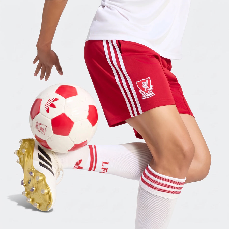 Red Adidas Liverpool FC 26/27 Away Shorts with white stripes, worn by a soccer player juggling a red and white ball.