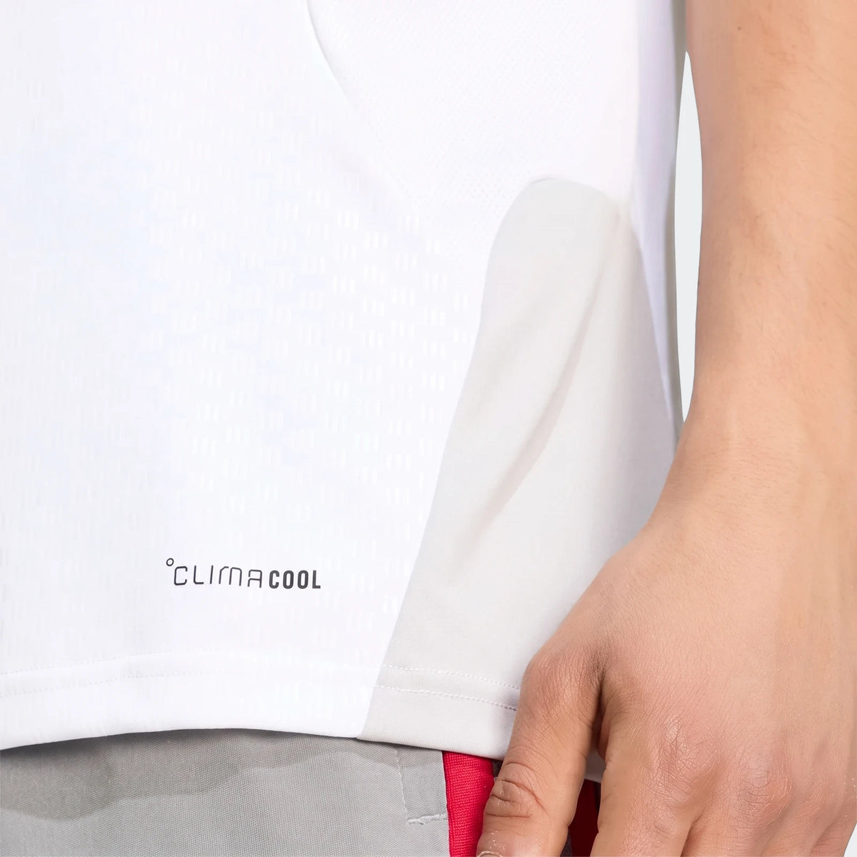Close-up of a person wearing a white and grey Liverpool Fc 26/27 Cup Tiro Training Jersey with a CLIMACOOL logo.