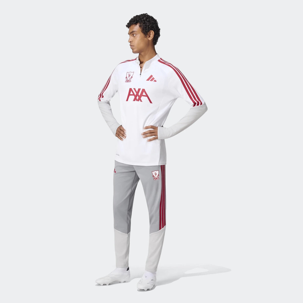 Full-body shot of a male model wearing the white Liverpool FC 26/27 Cup Tiro training top with grey pants and white cleats.