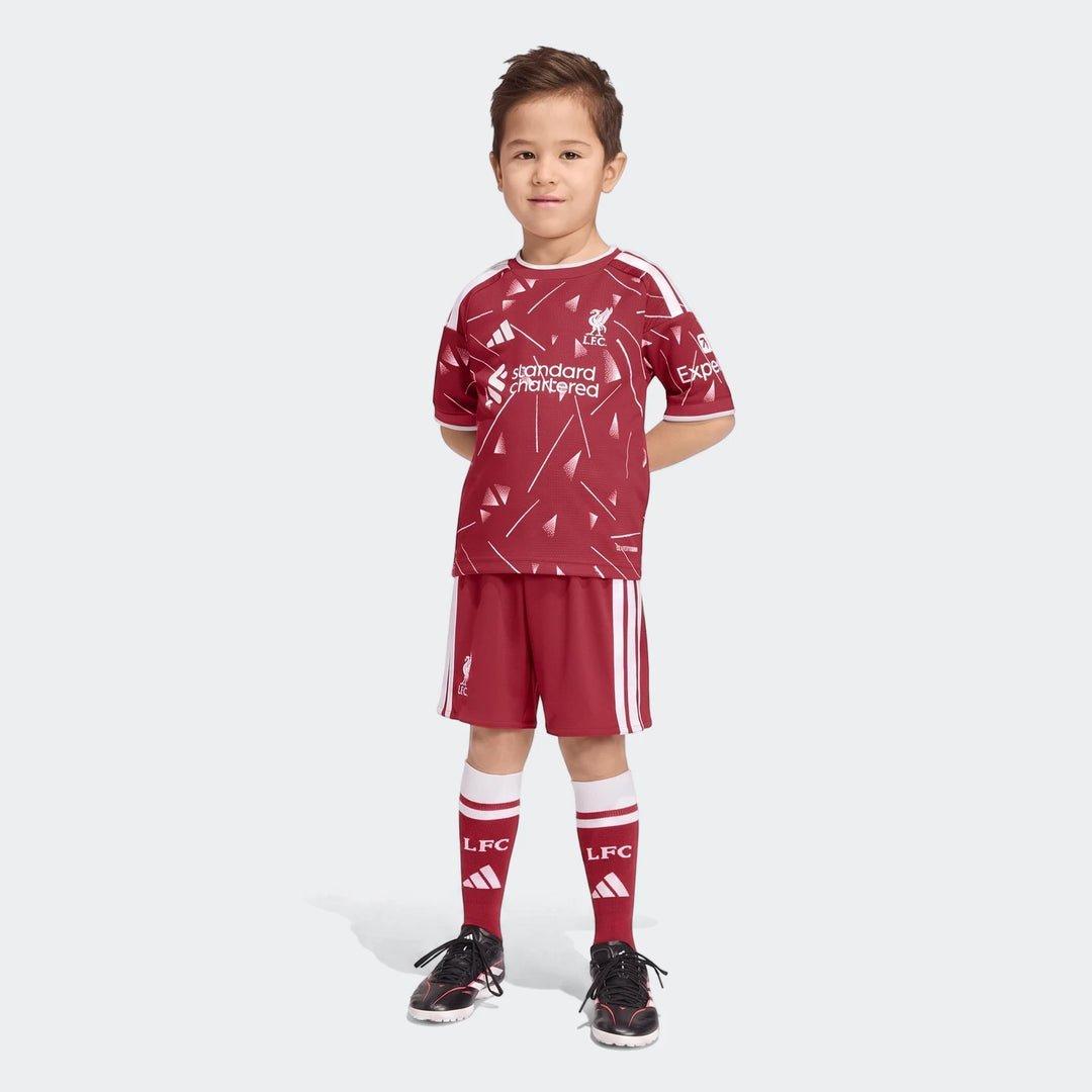 A young boy wearing the red and white Liverpool FC 26/27 Home Kids Set, featuring jersey, shorts, and socks.