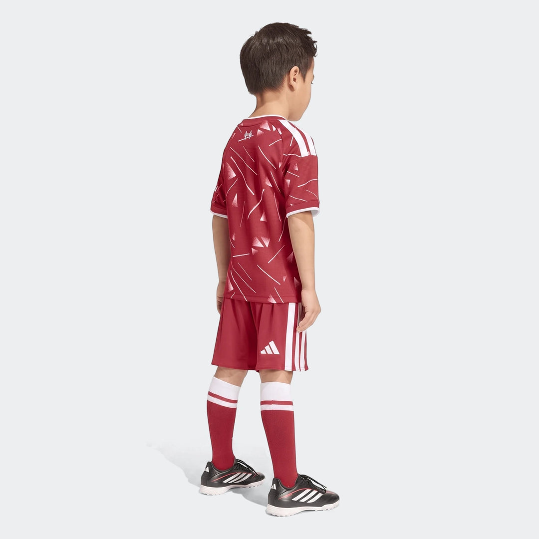 Young boy wearing a red Liverpool FC 26/27 Home Kids Set, featuring a patterned jersey, matching shorts, and socks, seen