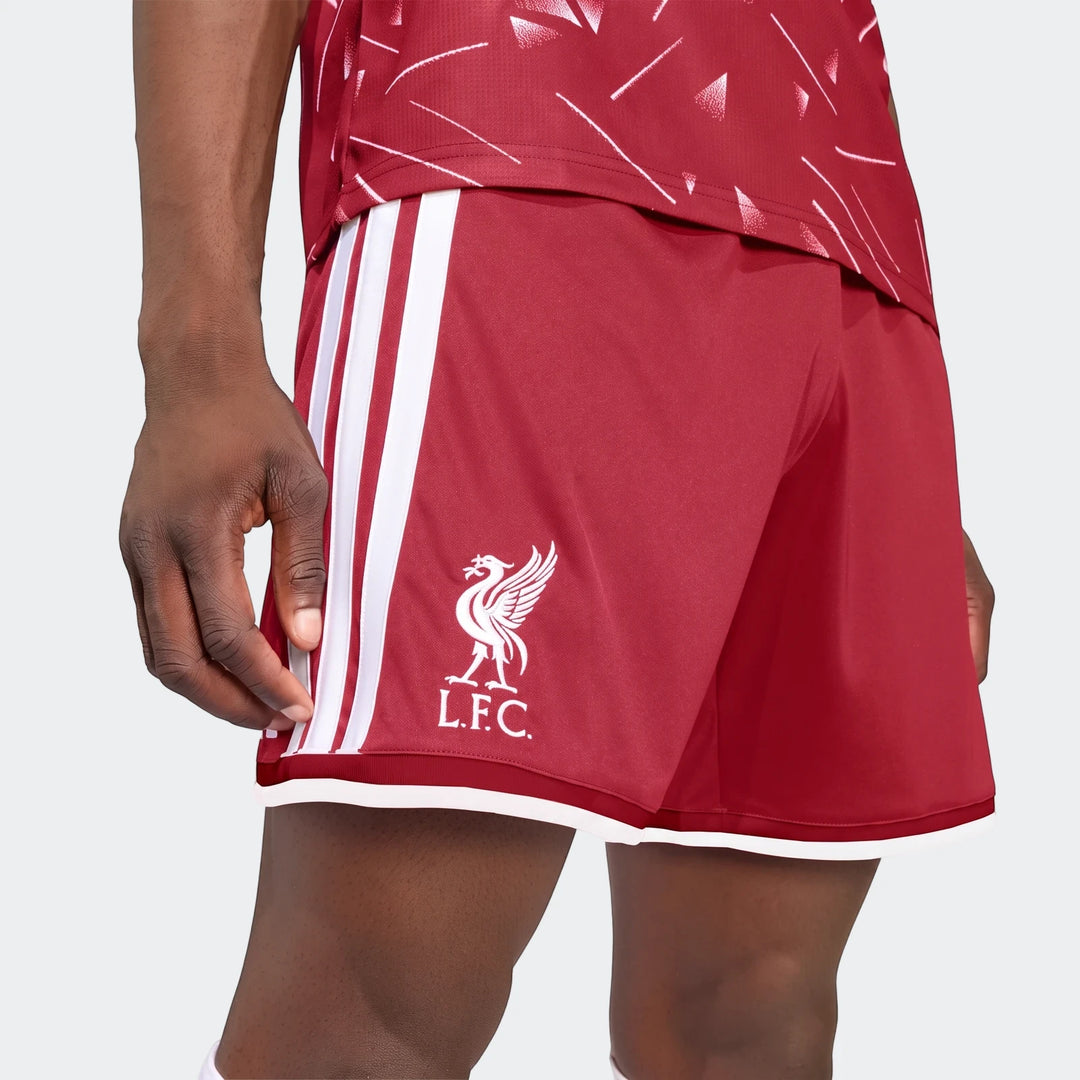 Close-up of a model wearing red Liverpool FC 26/27 Home Shorts with white Adidas stripes and L.F.C. crest.