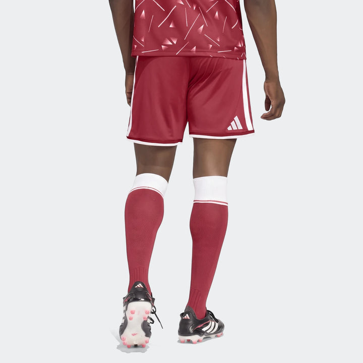 Rear view of a person wearing Liverpool FC 26/27 Home Shorts in red with white stripes, matching jersey, socks, and black