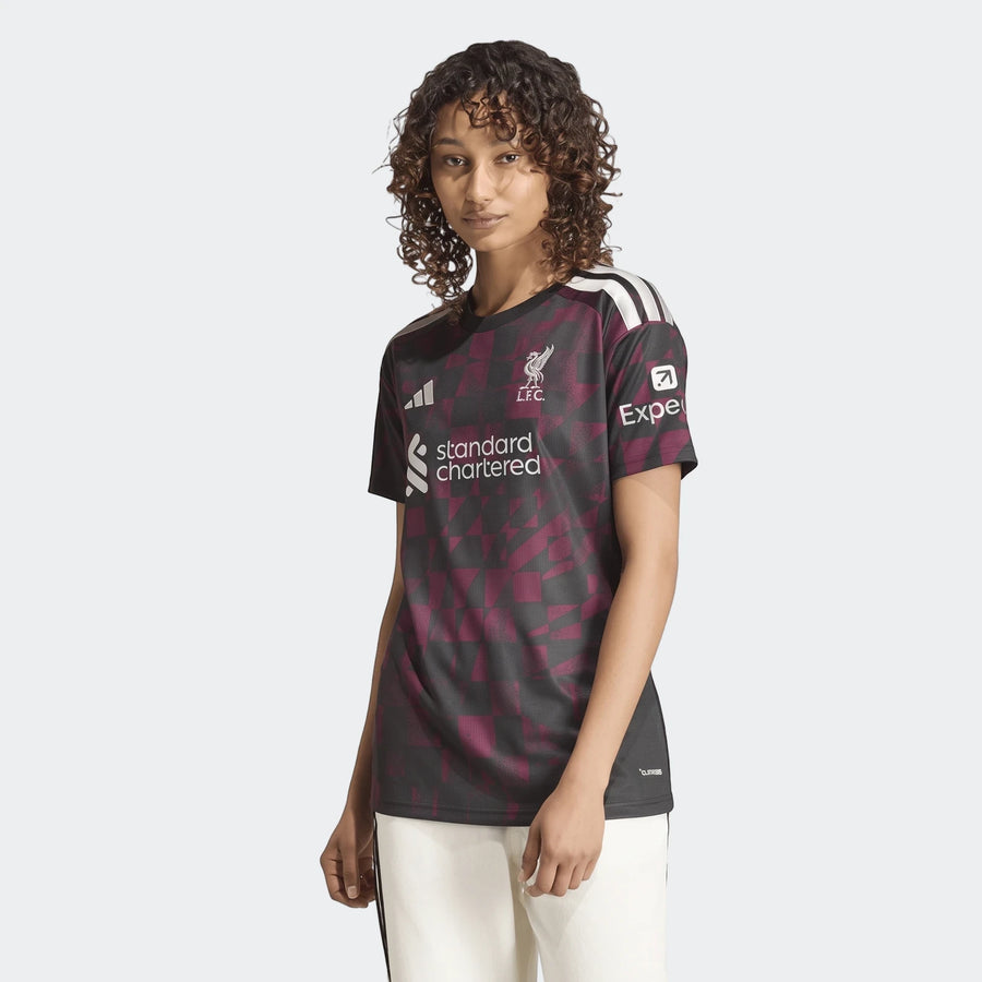 Female model wearing the Liverpool FC 26/27 Third Jersey, featuring a black and maroon geometric pattern with sponsor logos.