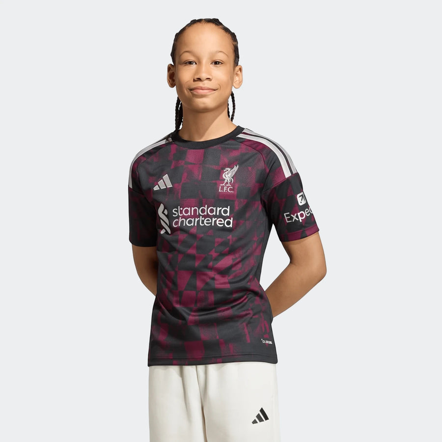 Young boy models a Liverpool FC 26/27 Third Jersey for kids, featuring a black and maroon geometric pattern and short