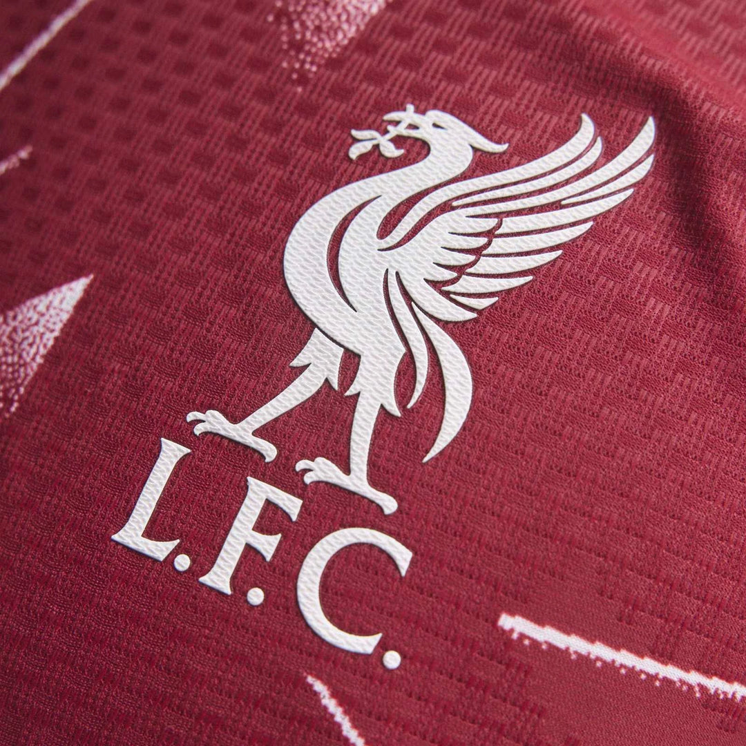 Close-up of Liverpool FC 26/27 Home Jersey Authentic showing white LFC crest on deep red fabric.