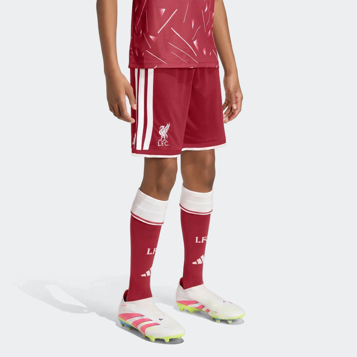 Liverpool FC 26/27 home shorts for kids in red with white side stripes and LFC crest, front view.