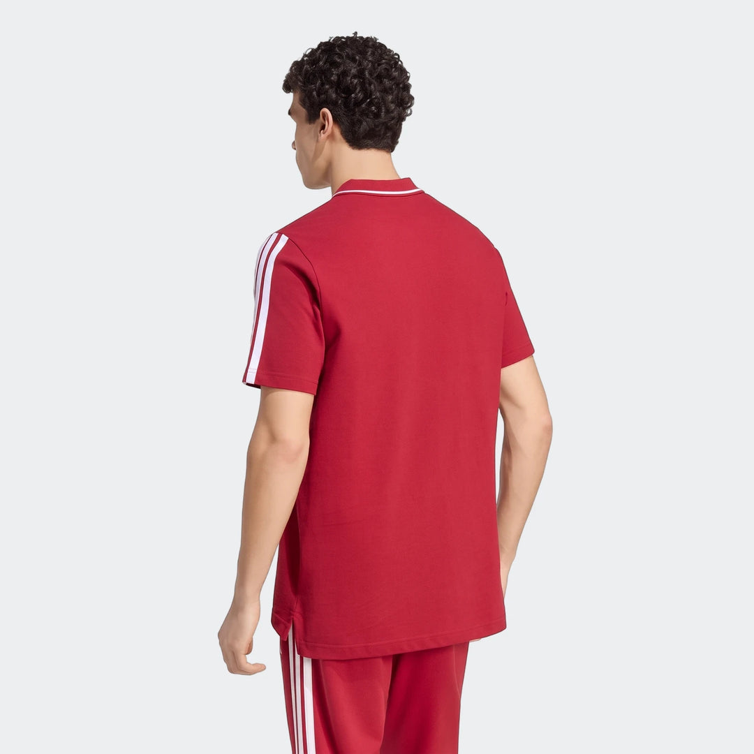 Male model from back wearing a red Liverpool FC DNA Polo Shirt with white stripes and matching track pants.