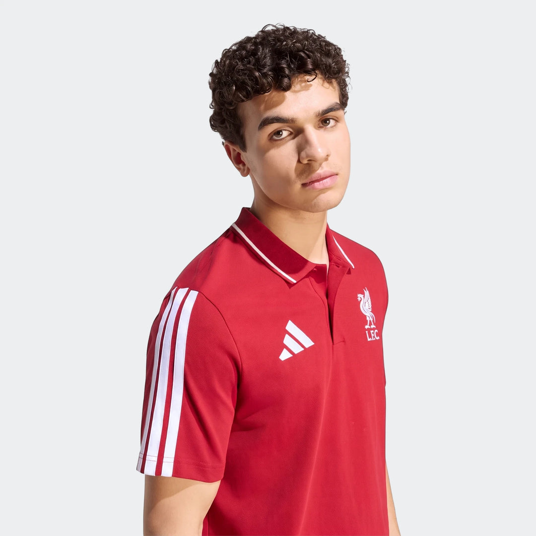 Red men's Liverpool FC DNA polo shirt with white Adidas logo and crest, featuring three stripes on the sleeve, worn by a