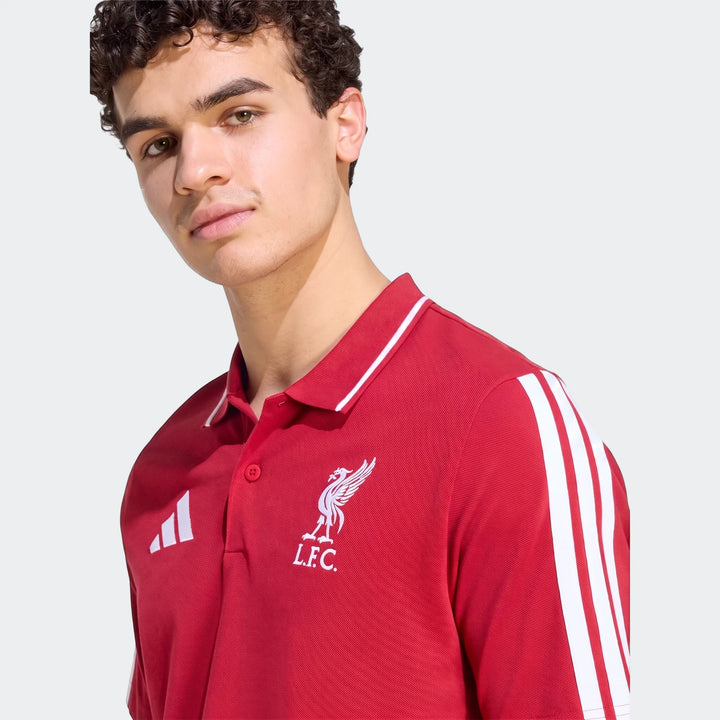 Young man wearing a red Liverpool FC DNA Polo Shirt featuring the club's crest and Adidas branding, shown from the chest up.