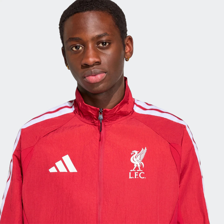 Young man wearing a red Liverpool FC Home Anthem Jacket with white stripes and team crest, front view.