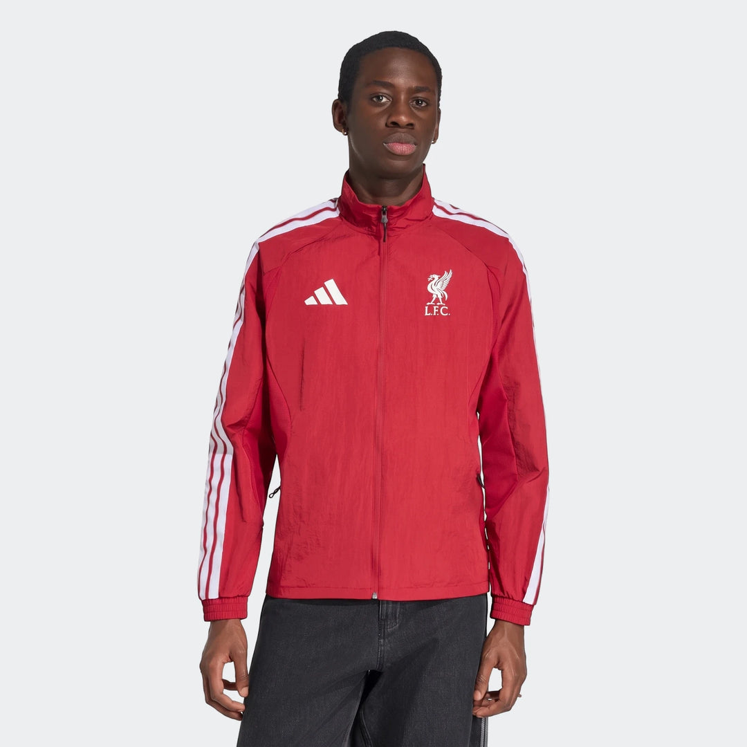 Male model wearing a red Adidas Liverpool FC Home Anthem Jacket with white stripes and team crest, shown from the waist up.