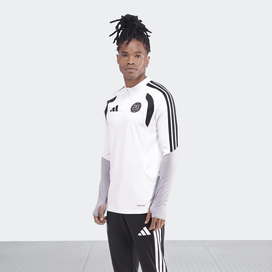 Male model wearing an Adidas Op Tiro26C Top in white with black and gray accents, paired with black Adidas track pants. He