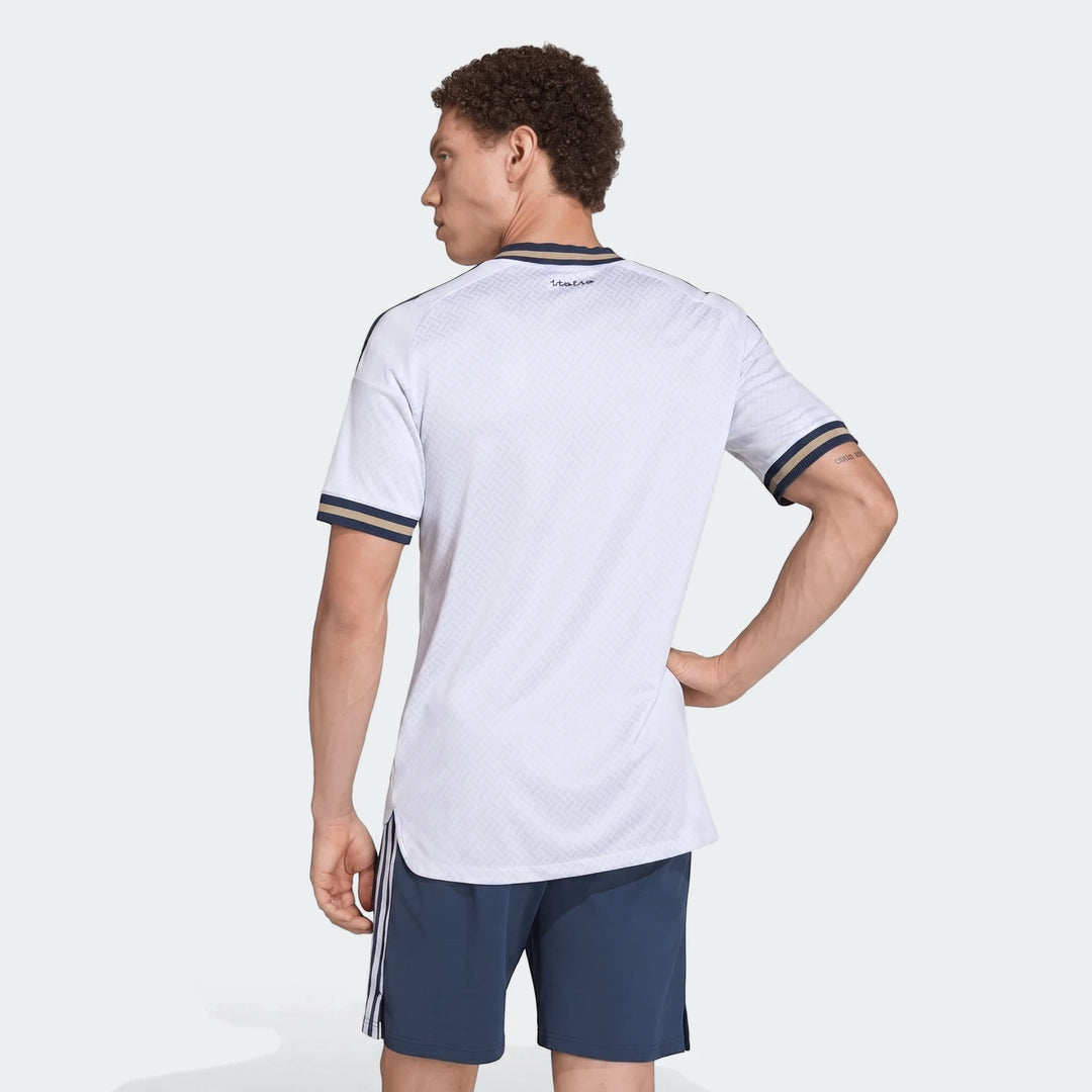 Male model in white patterned Z.N.E. Track Top with striped cuffs and navy shorts, shown from the back.