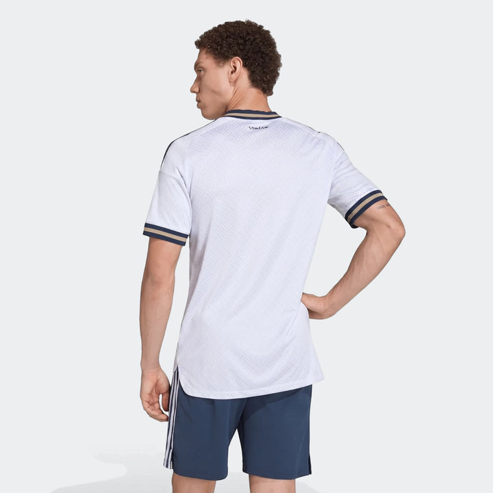 Male model in white patterned Z.N.E. Track Top with striped cuffs and navy shorts, shown from the back.