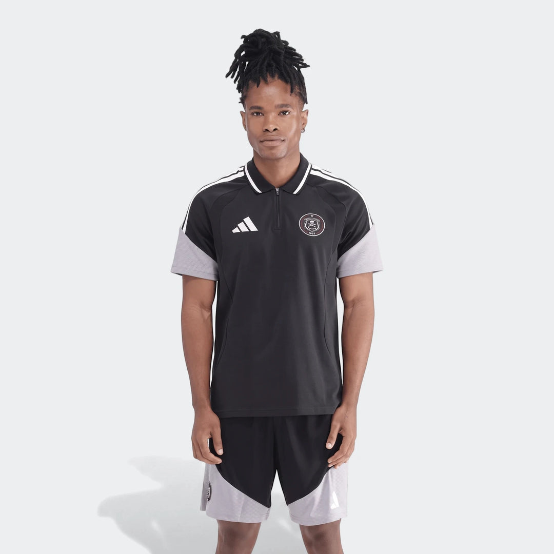 Full body shot of a man wearing a black and grey Adidas Op Tiro26C polo shirt with matching shorts, showcasing the sporty