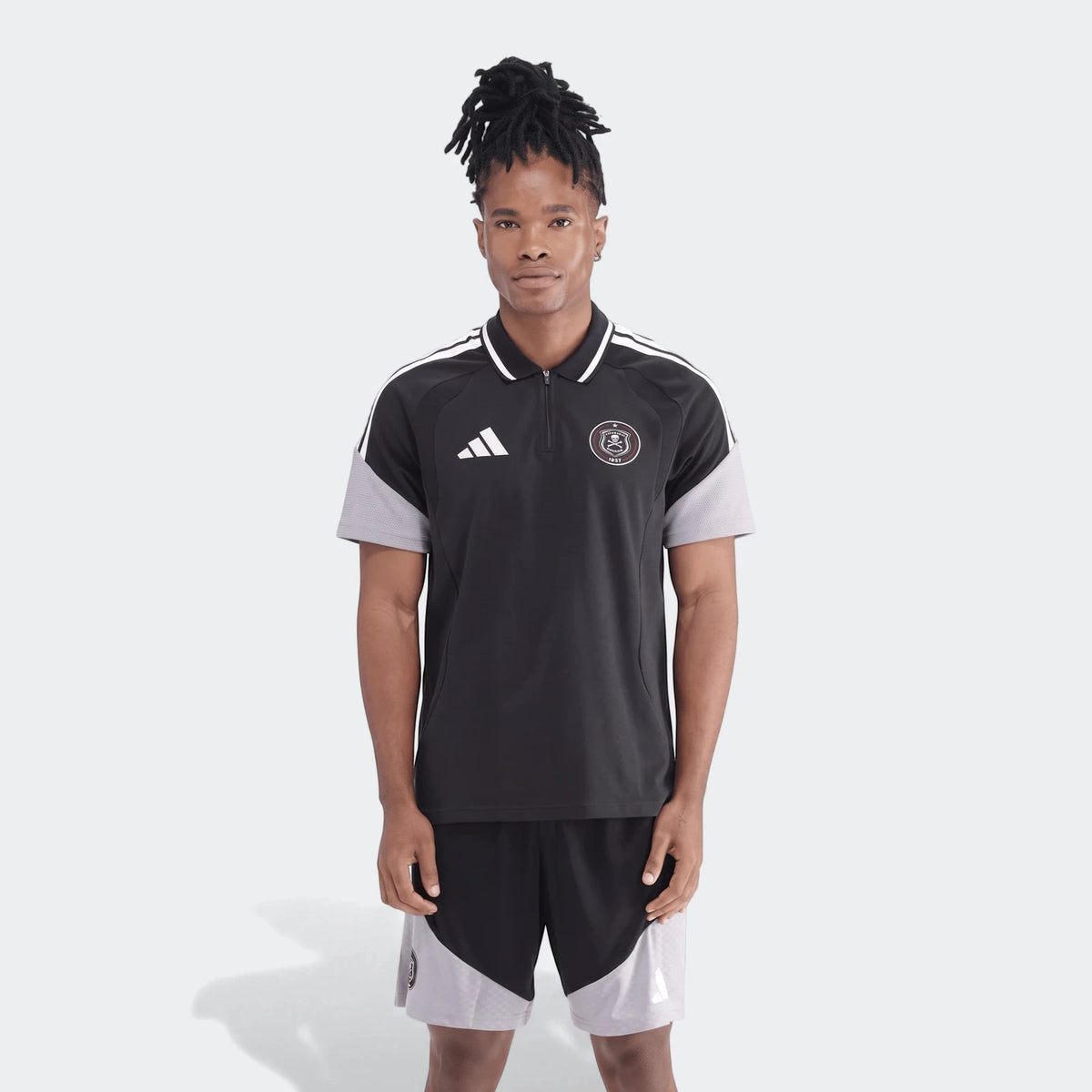 Full body shot of a man wearing a black and grey Adidas Op Tiro26C polo shirt with matching shorts, showcasing the sporty