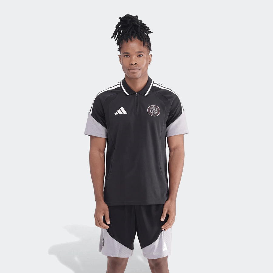 Full body shot of a man wearing a black and grey Adidas Op Tiro26C polo shirt with matching shorts, showcasing the sporty