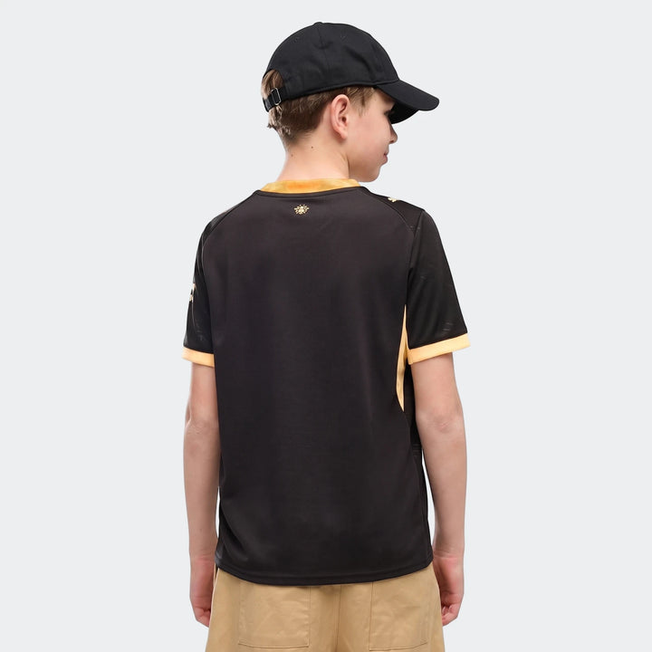 Youth Manchester City 26/27 Away Jersey in black and yellow, shown on a boy from the back with a black cap.
