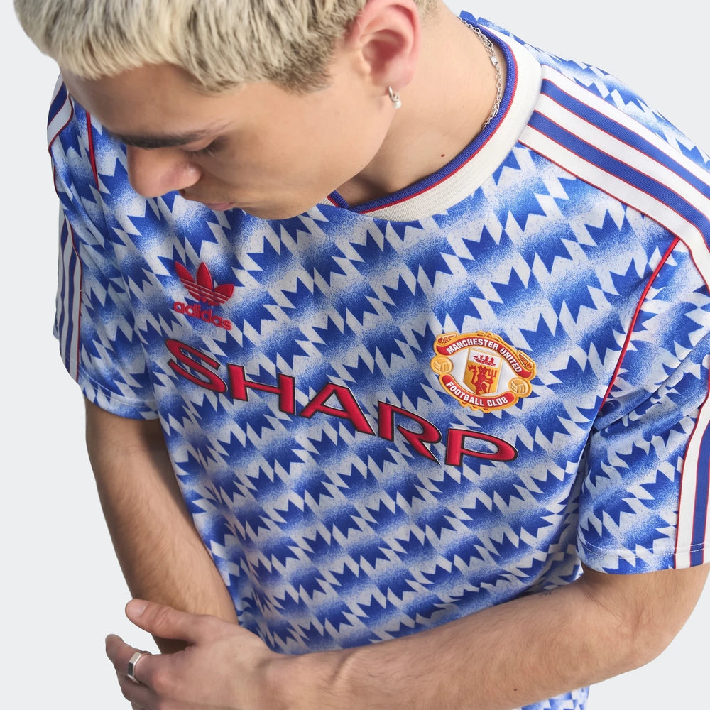 Manchester United 1990 away jersey close-up in blue and white zigzag print with red trim and club crest