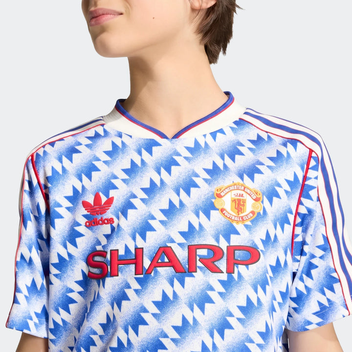Manchester United 1990 Away Jersey Kids, front view in blue and white geometric print with V-neck and club crest.