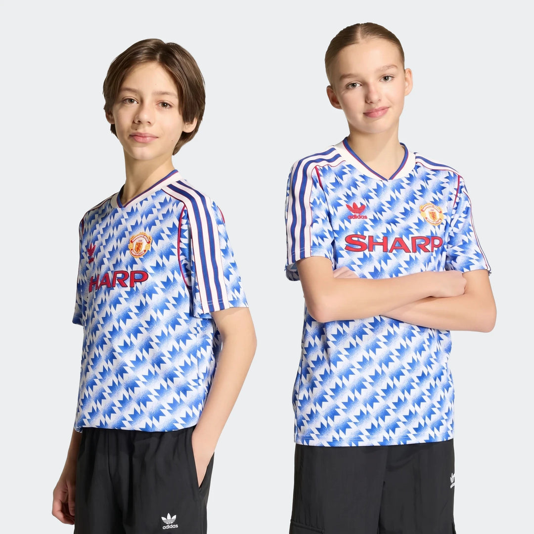 Manchester United 1990 Away Jersey Kids in blue and white zigzag pattern, short sleeve V-neck with red trim.