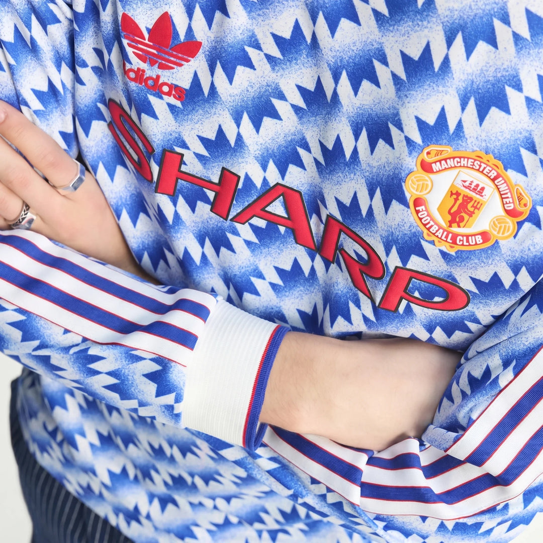 Manchester United 1990 Long Sleeve Away Jersey close up showing blue and white pattern, club crest, and sleeve stripes