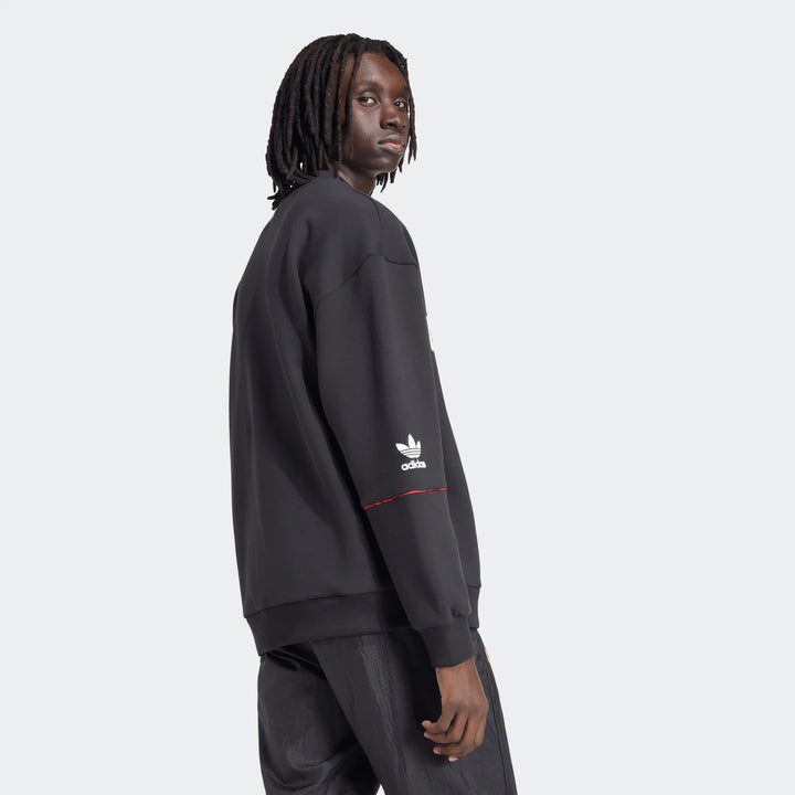 Manchester United 1990 sweatshirt in black, long-sleeve crewneck shown from side with adidas logo on sleeve.