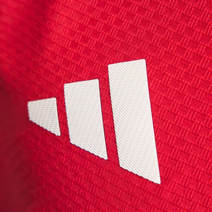 Manchester United 26/27 Authentic Long Sleeve Home Jersey close-up showing red textured fabric and white logo detail.