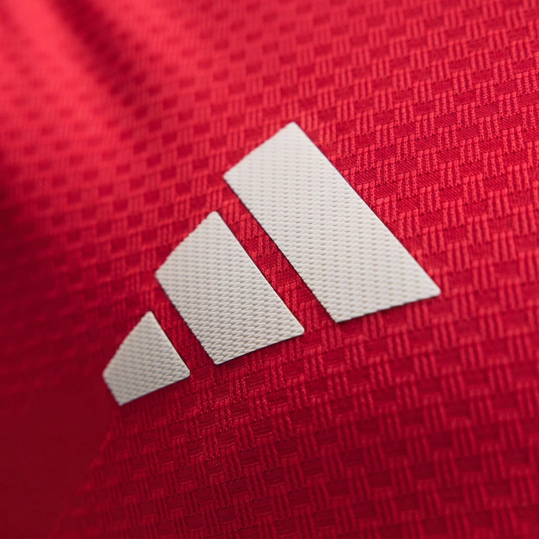 Manchester United 26/27 Authentic Home Jersey close-up showing red textured fabric with white adidas logo detail