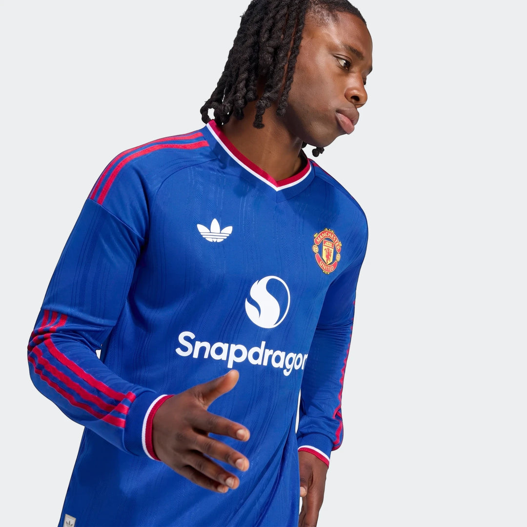 Manchester United 26/27 Away Authentic Jersey Longsleeve for men, featuring blue fabric, red stripes, and team crest.
