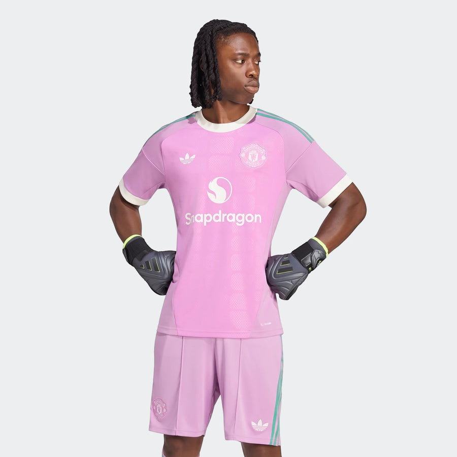 Male model showcasing the pink Manchester United 26/27 Away Goalkeeper Jersey and matching shorts with gloves, featuring