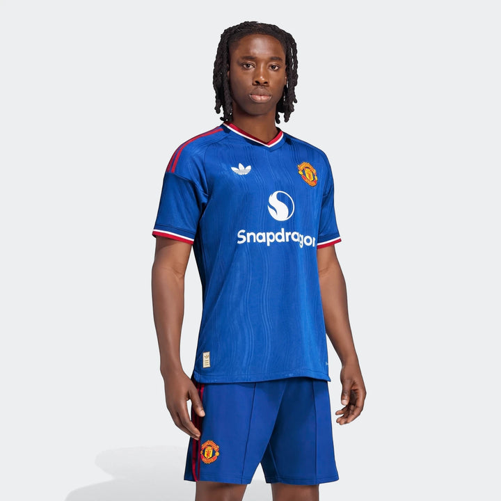 Manchester United 26/27 Away Jersey Authentic and matching shorts on a model, in blue with red details.