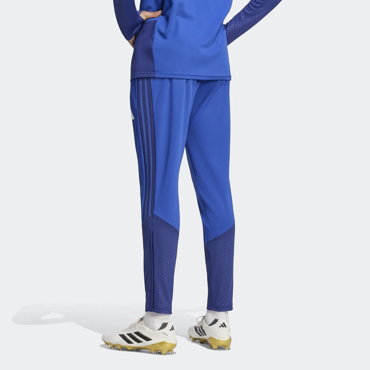 Blue Adidas Manchester United 26/27 Cup Tiro Training Pants worn by a person, viewed from the back, paired with white and
